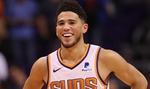 Devin Booker smiling at the camera following a match.